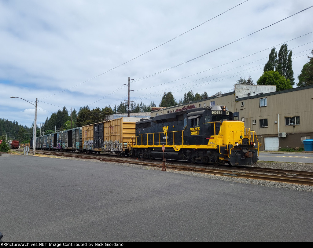 WAMX 3021 pulling boxcars in town